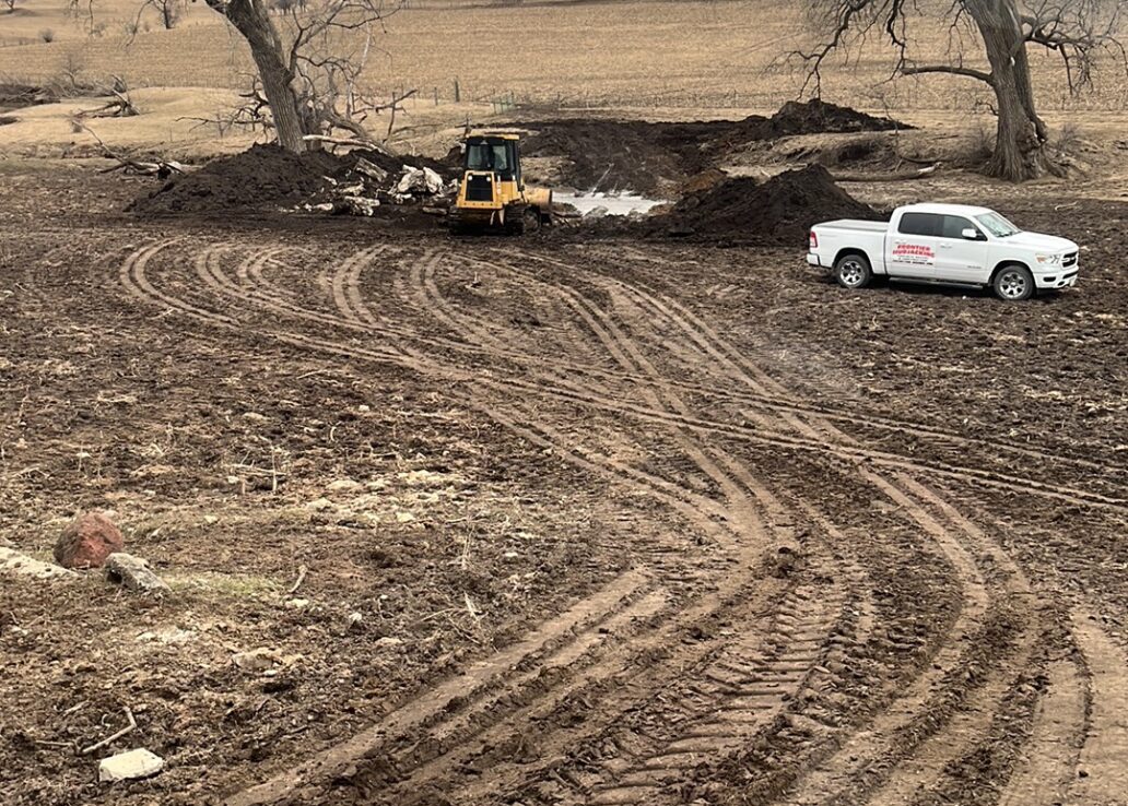 frontier mudjacking truck and skid loader in dirt area