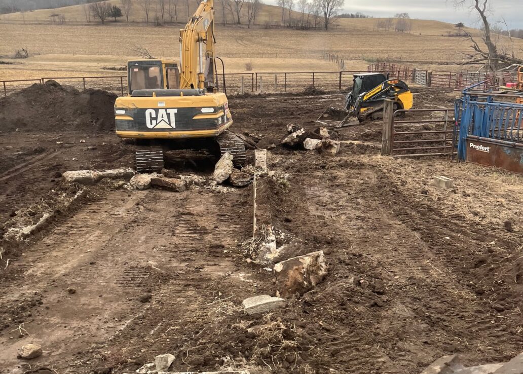 skid loader and excavator in mud area